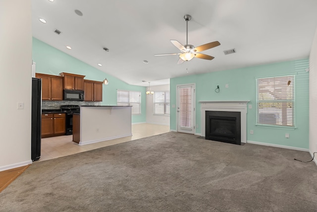 kitchen featuring backsplash, lofted ceiling, light carpet, black appliances, and ceiling fan with notable chandelier