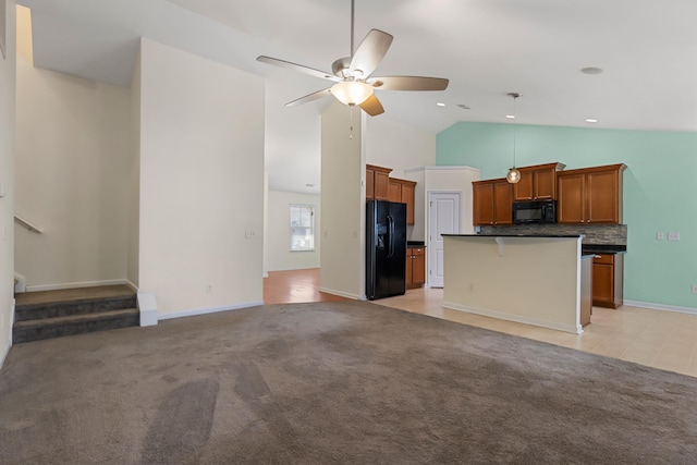 kitchen featuring ceiling fan, a center island, tasteful backsplash, a breakfast bar, and black appliances