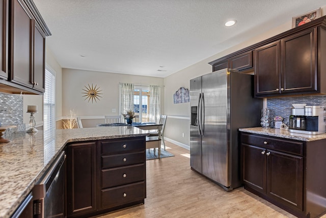 kitchen with appliances with stainless steel finishes, light hardwood / wood-style flooring, dark brown cabinets, and plenty of natural light