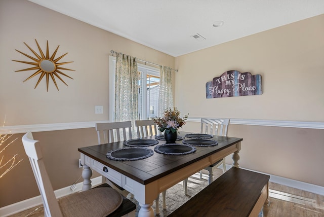 dining space with wood-type flooring