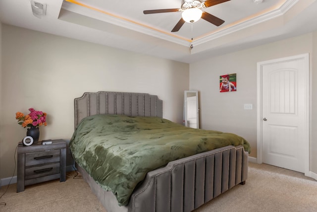 bedroom featuring a raised ceiling, ceiling fan, and light colored carpet