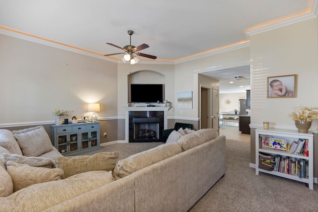 living room featuring ceiling fan, crown molding, and light carpet