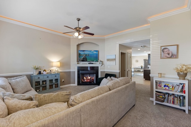 living room with light colored carpet, ceiling fan, and crown molding