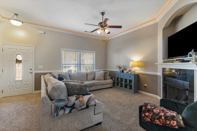 living room featuring carpet, ceiling fan, and crown molding