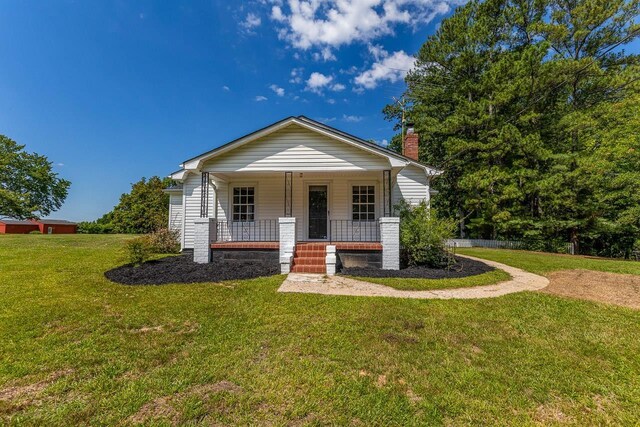 bungalow featuring a front lawn and a porch