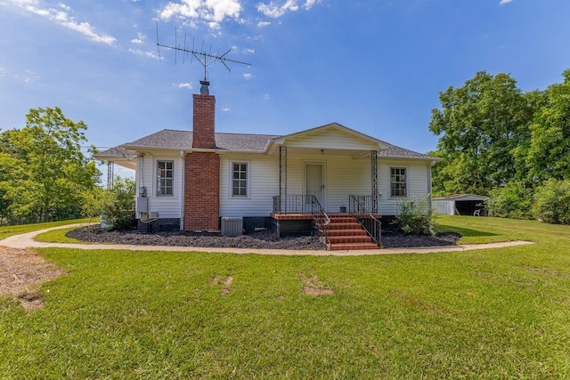 back of property with a lawn and central AC