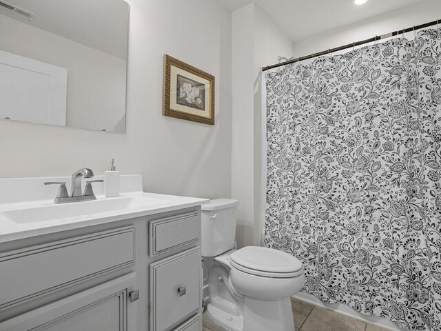 bathroom with tile patterned flooring, vanity, and toilet