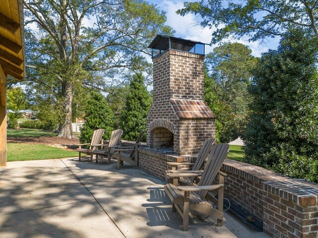 view of patio with an outdoor brick fireplace