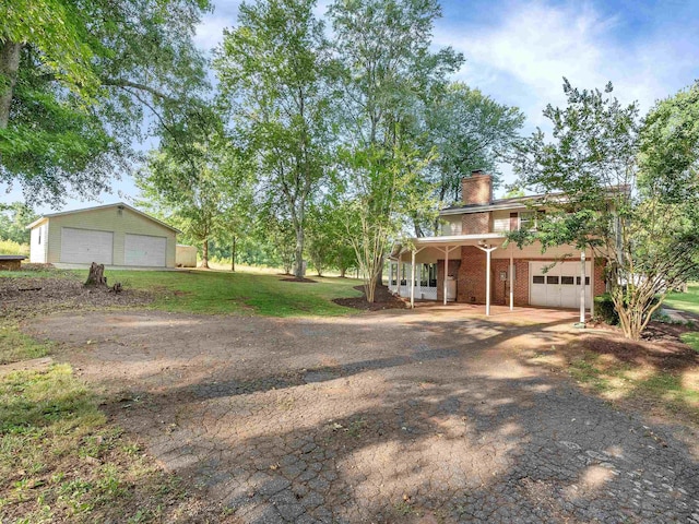 view of front of property featuring covered porch, a garage, and a front yard