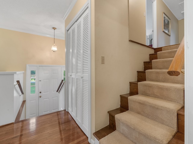 foyer entrance with hardwood / wood-style floors and crown molding