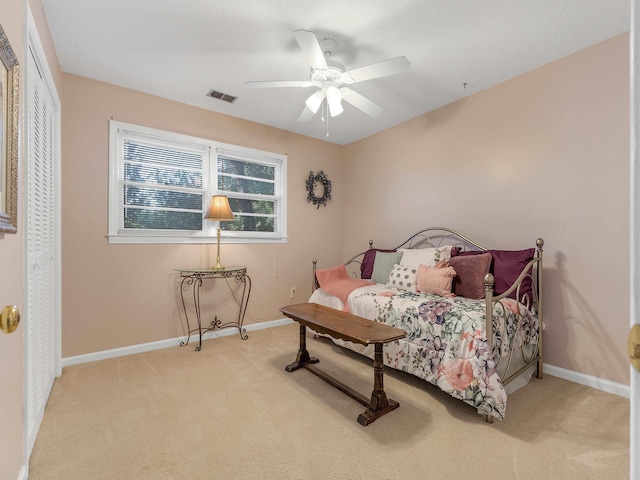 carpeted bedroom featuring ceiling fan and a closet