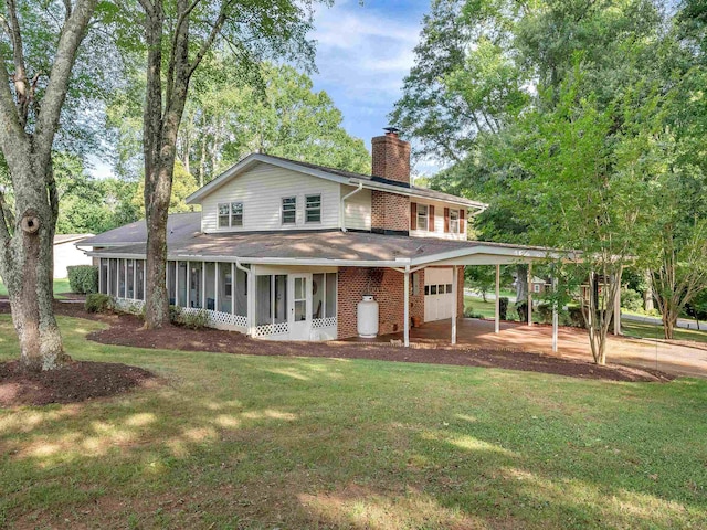 exterior space featuring a yard, a garage, a carport, and a sunroom