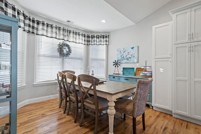 dining room featuring light hardwood / wood-style floors and vaulted ceiling