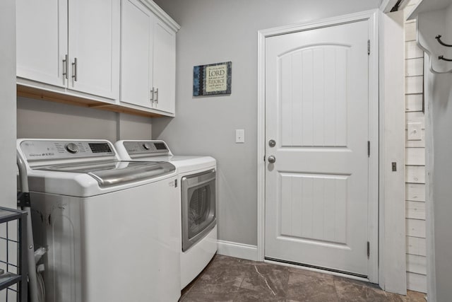 clothes washing area featuring cabinets and independent washer and dryer