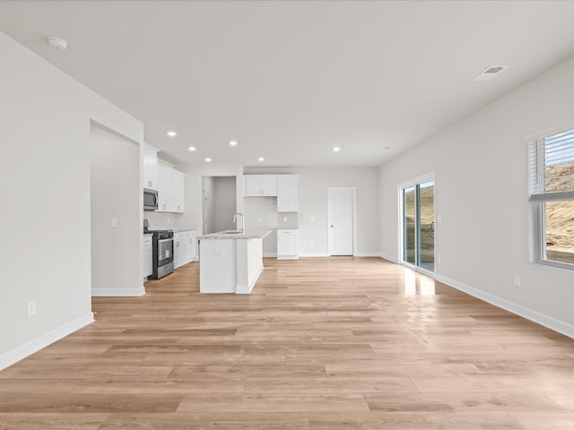 unfurnished living room with sink and light hardwood / wood-style flooring