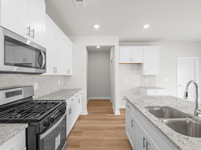 kitchen featuring stainless steel appliances, sink, and white cabinets