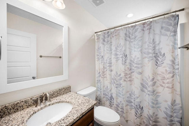 bathroom featuring a shower with shower curtain, vanity, and toilet