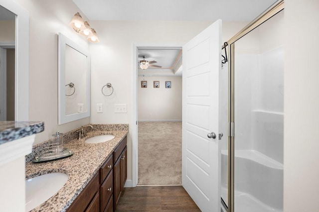 bathroom with hardwood / wood-style floors, vanity, ceiling fan, and walk in shower