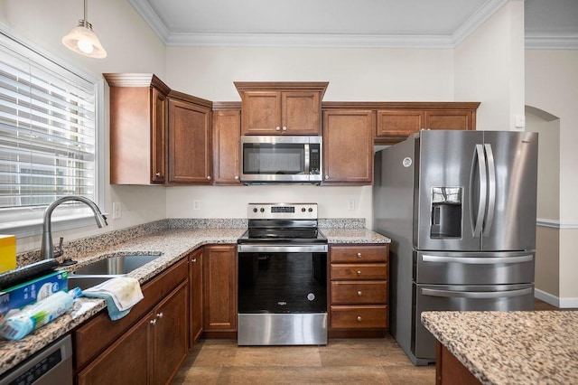 kitchen with pendant lighting, light stone countertops, stainless steel appliances, and ornamental molding