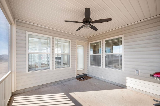 unfurnished sunroom featuring a wealth of natural light and ceiling fan