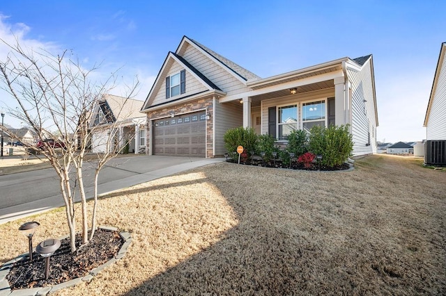 view of front of home featuring covered porch, a garage, and central air condition unit