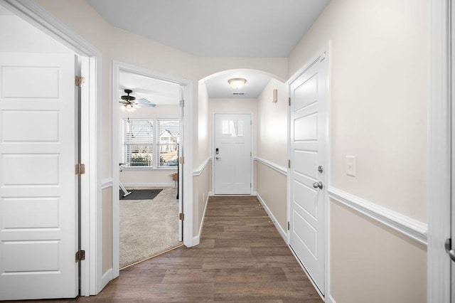 doorway with ceiling fan and dark wood-type flooring