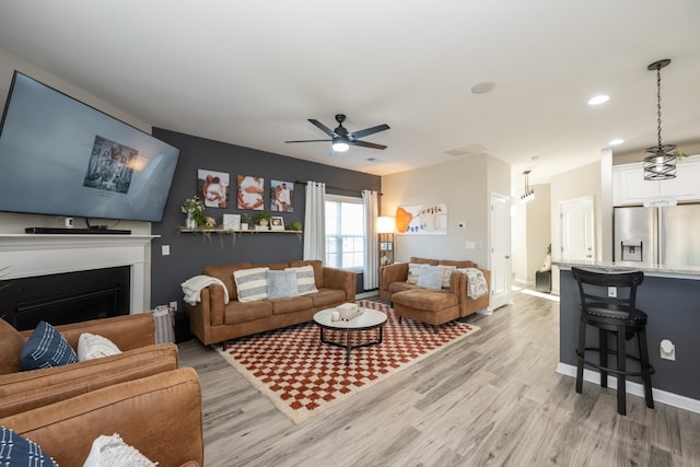 living room with ceiling fan and light hardwood / wood-style floors