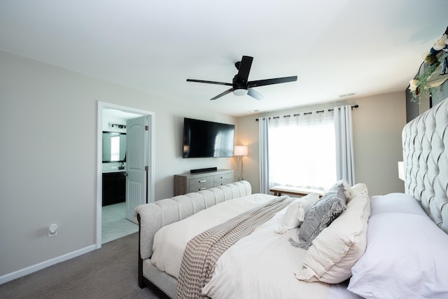 carpeted bedroom with ceiling fan and ensuite bath