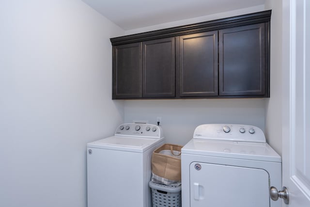 washroom with cabinets and washer and dryer