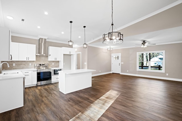 kitchen with white cabinets, decorative light fixtures, electric stove, and wall chimney range hood