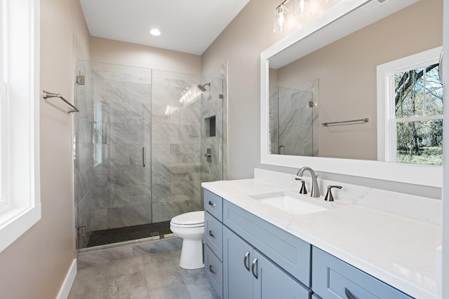 bathroom featuring vanity, toilet, and a shower with door