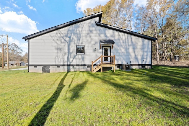 back of house featuring a lawn and cooling unit