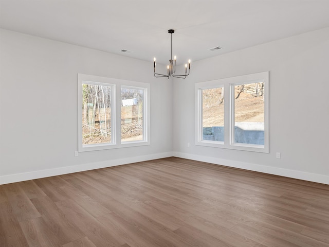 unfurnished dining area featuring light hardwood / wood-style flooring and a notable chandelier