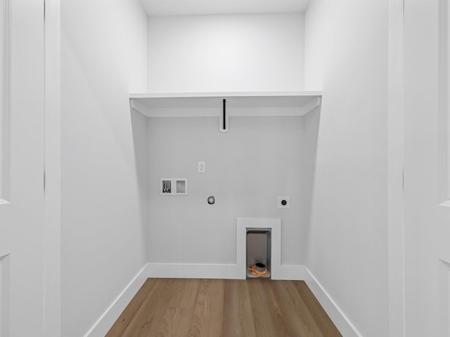 clothes washing area with hookup for an electric dryer, hookup for a washing machine, light hardwood / wood-style floors, and gas dryer hookup