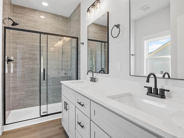 bathroom with vanity, wood-type flooring, and an enclosed shower