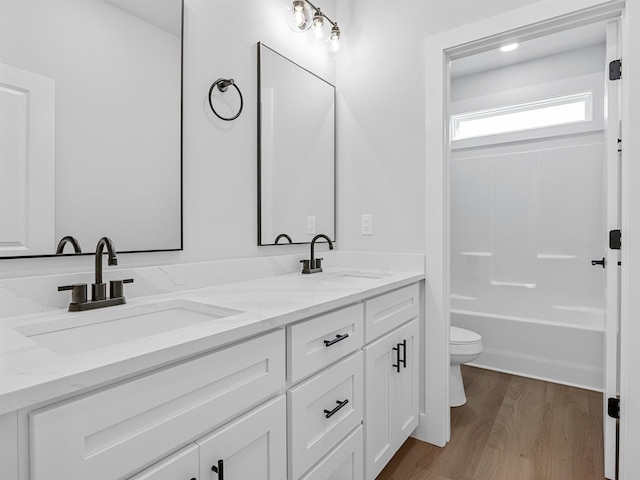 full bathroom featuring hardwood / wood-style floors, vanity, shower / bath combination, and toilet