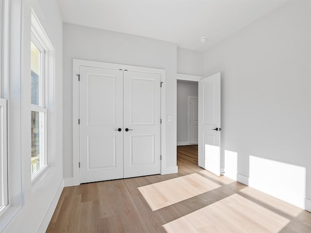 unfurnished bedroom featuring light hardwood / wood-style floors and a closet