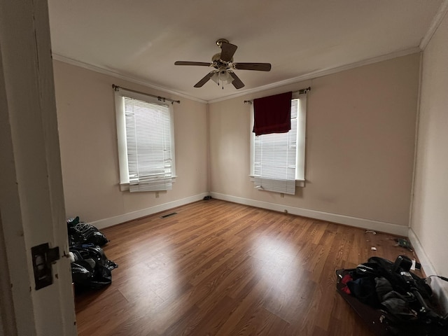 unfurnished room featuring ceiling fan, wood-type flooring, and ornamental molding