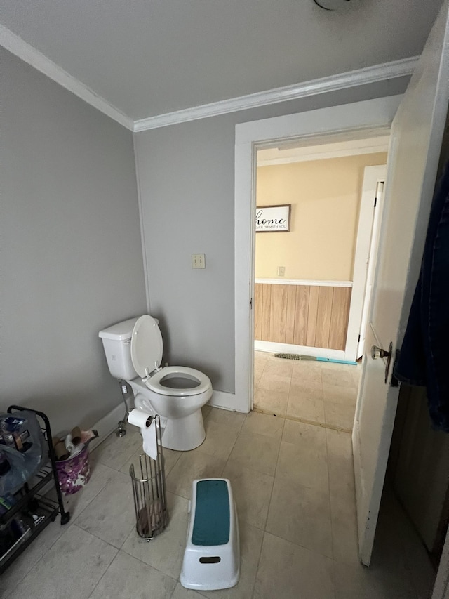 bathroom with tile patterned flooring, toilet, and crown molding