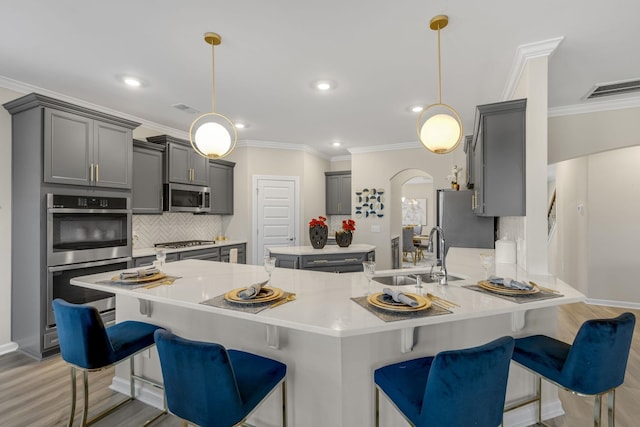 kitchen featuring gray cabinetry, sink, hanging light fixtures, and appliances with stainless steel finishes