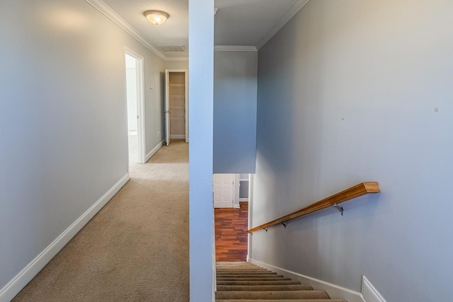 staircase with carpet floors and ornamental molding