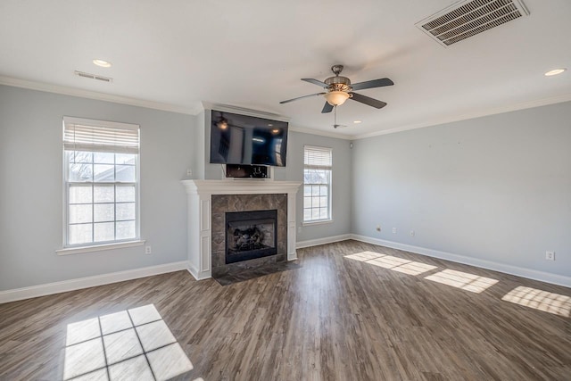 unfurnished living room featuring hardwood / wood-style flooring, ceiling fan, crown molding, and a tiled fireplace