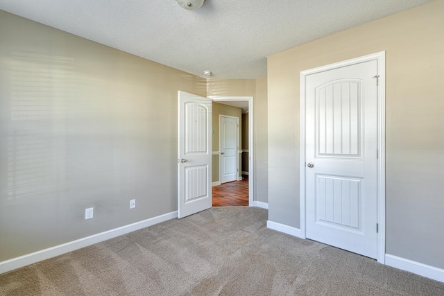 unfurnished bedroom featuring carpet and a textured ceiling