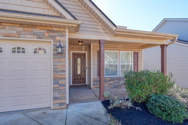 doorway to property with covered porch and a garage