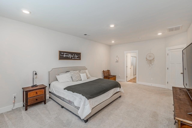 bedroom with connected bathroom and light colored carpet