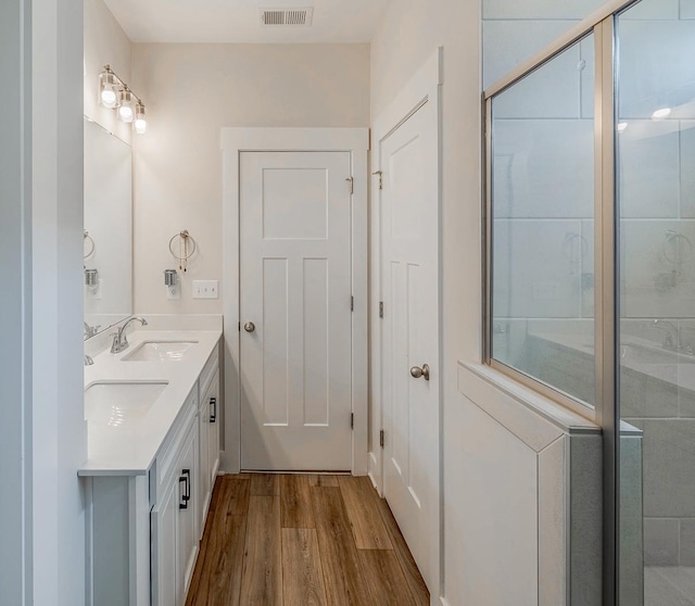 bathroom featuring vanity, an enclosed shower, and wood-type flooring