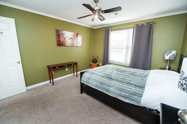 bedroom with ceiling fan, crown molding, and carpet floors