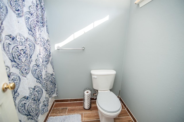 bathroom with a shower with curtain and toilet