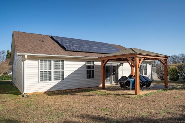 rear view of property featuring a gazebo, solar panels, a yard, and a patio