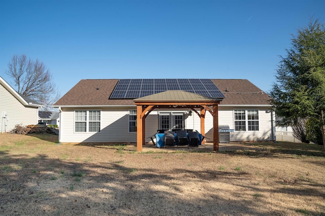 back of house with a gazebo, a patio area, a lawn, and solar panels